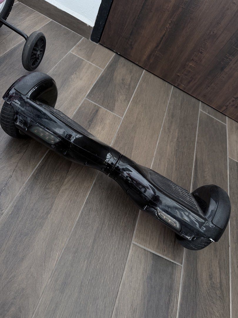 Hoverboard (Category: Hoverboards) located in Singapore. Submitted by chewylee (Listing ID 1467013189, Image 4). Description: - comes with a carry case and charger - Features: Rubber foot pads, solid wheels, standard charging port, and rear power button - Condition: Fully functional with visible scuffs and scratches on the body; normal wear on wheels and hubcaps - Deal: Self-collection preferred in woodlands area.