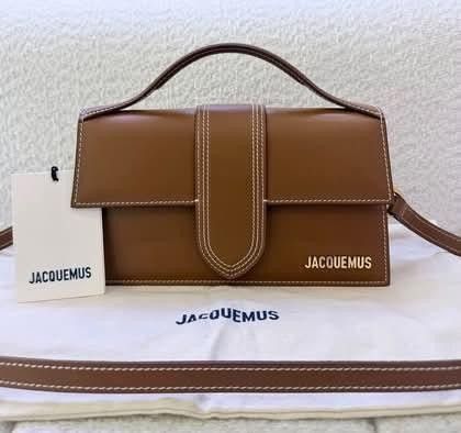 Jacquemus Brown Leather Shoulder Bag (Category: Luxury Bags & Wallets) located in Manila. Submitted by catpanganiban_ (Listing ID 1467118610, Image 1). Description: - Authentic Jacquemus brown leather top handle bag - Chic white contrast stitching and gold-tone metal hardware - Signature front lettering logo and back slip pocket - Structured flap design with secure closure - Includes detachable shoulder strap for versatile wear - Comes with origi
