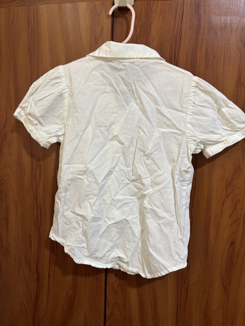 Janie and Jack White Button-Down Blouse (Category: Babies & Kids Fashion) located in Manila. Submitted by wardrobeinmnl (Listing ID 1466998720, Image 2). Description: - Brand: Janie and Jack - Size: 7 - Color: Classic white - Material: 100% clean cotton - Details: Short puff sleeves with gathered cuffs, traditional collar, and front button closure - Origin: Made in Indonesia - Styling: Versatile piece, easy to pair with skirts or trousers for sch