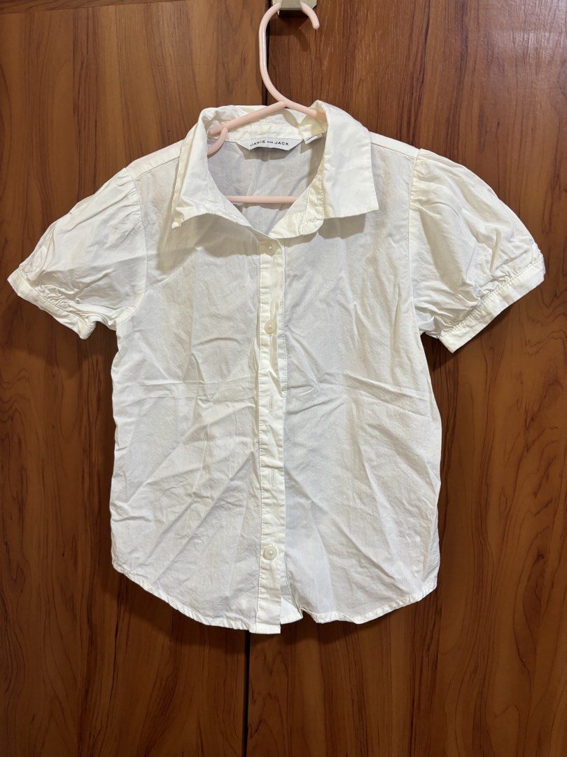 Janie and Jack White Button-Down Blouse (Category: Babies & Kids Fashion) located in Manila. Submitted by wardrobeinmnl (Listing ID 1466998720, Image 1). Description: - Brand: Janie and Jack - Size: 7 - Color: Classic white - Material: 100% clean cotton - Details: Short puff sleeves with gathered cuffs, traditional collar, and front button closure - Origin: Made in Indonesia - Styling: Versatile piece, easy to pair with skirts or trousers for sch