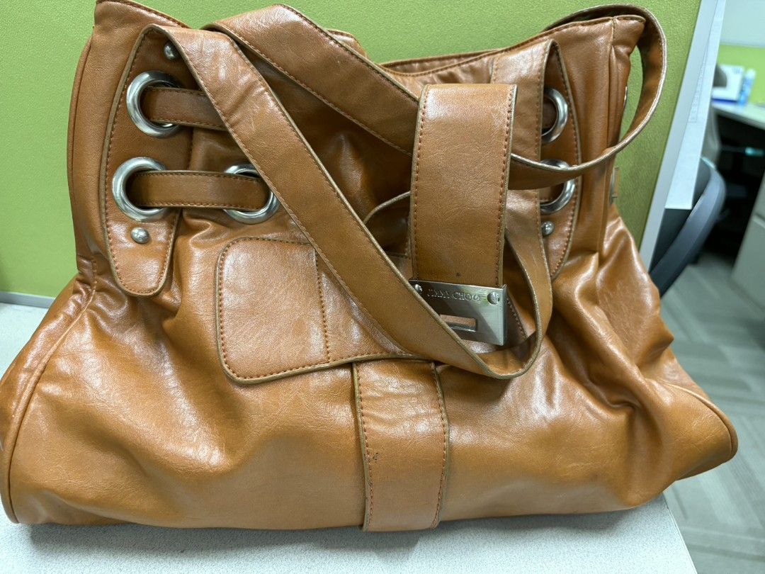 Jimmy Choo Tan Leather Shoulder Bag (Category: Luxury Bags & Wallets) located in Manila. Submitted by fushiqi0226 (Listing ID 1467007384, Image 1). Description: - Authentic Jimmy Choo tan leather shoulder bag - Chic slouchy design accented with edgy metal grommets - Secure large central strap closure with engraved metal hardware plate - Comfortable double shoulder straps for easy daily wear - Spacious interior compartment to fit all your daily es
