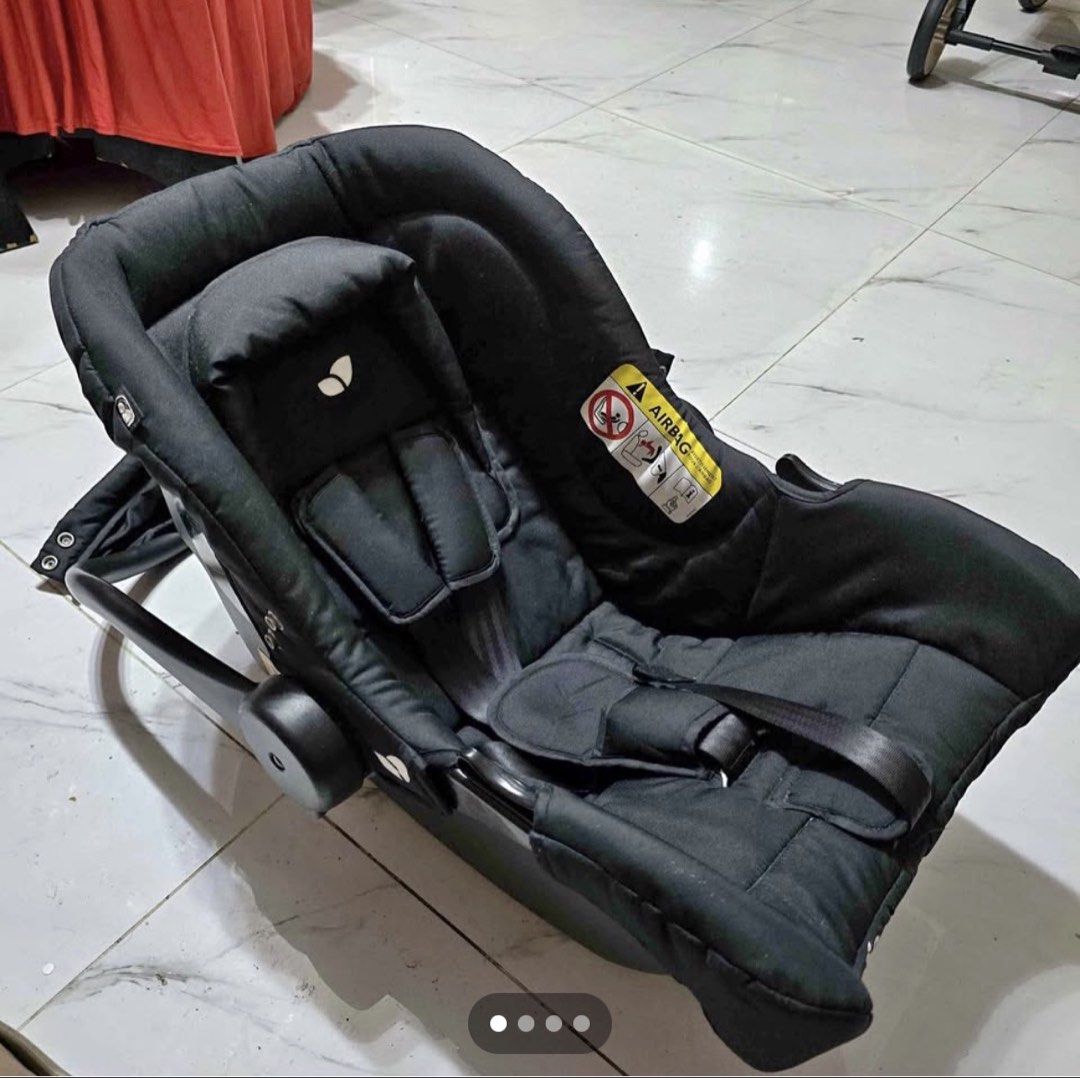 Joie Infant Car Seat Black (Category: Car Seats) located in Pasig City. Submitted by artemissk (Listing ID 1467152897, Image 2). Description: - Brand/Model: Joie baby car seat - Color: Solid black with clean fabric upholstery - Type: Rear-facing infant carrier style - Safety & Comfort: Built-in harness straps with shoulder pads and removable head support insert - Features: Adjustable carry handle and standard safety warnings on the side - Conditi