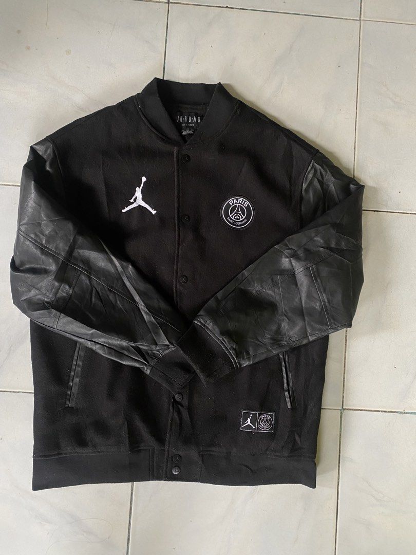 Jordan x Paris Saint-Germain Varsity Jacket Black (Category: Coats, Jackets and Outerwear) located in Iloilo. Submitted by laughthrift_goods (Listing ID 1467168066, Image 1). Description: - Authentic Jordan x Paris Saint-Germain collaboration varsity jacket - Classic black wool body with durable faux leather sleeves - Detailed embroidered PSG crest on the chest - Large white 'PARIS' block patch on the back with iconic Jumpman logo - Traditional b