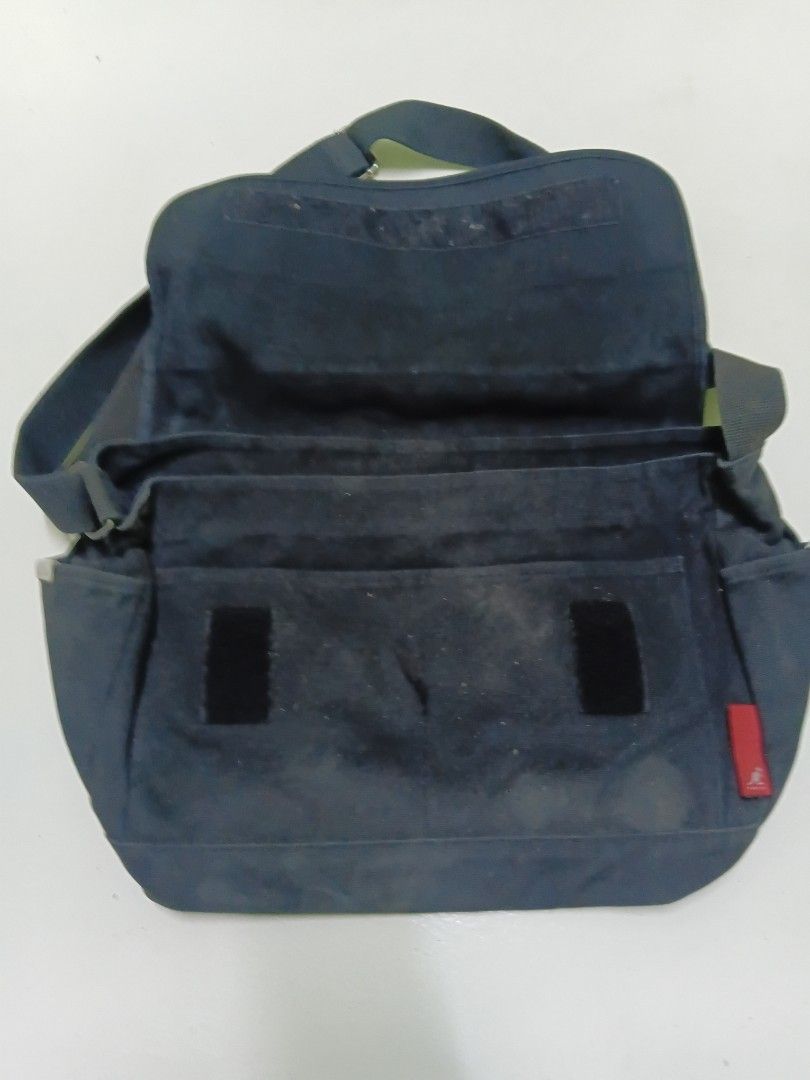 Kangol Black Canvas Messenger Bag (Category: Sling Bags) located in Manila. Submitted by daphnefinds1 (Listing ID 1467103078, Image 2). Description: - Brand: Kangol - Material: Durable black canvas - Closure: Flap with secure velcro strips - Storage: Main compartment for daily essentials + interior zip pocket - Strap: Adjustable shoulder strap for custom fit - Details: Red exterior tag with silver Kangol text and iconic kangaroo logo - Condition: