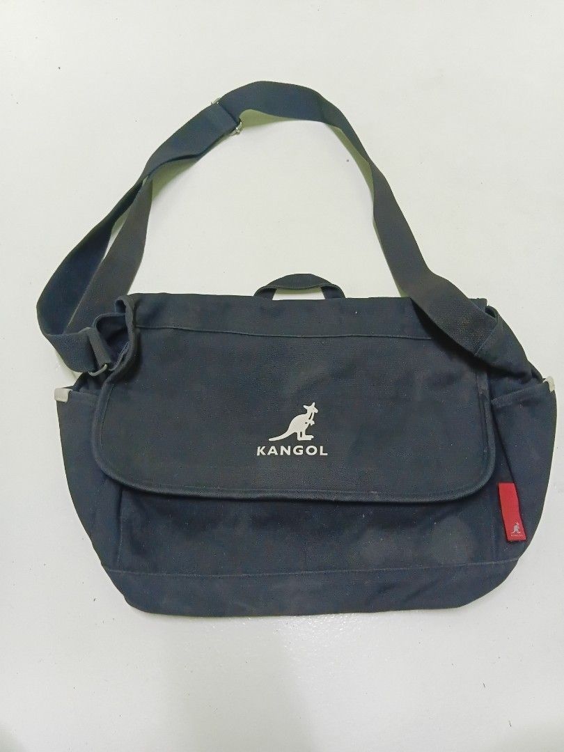 Kangol Black Canvas Messenger Bag (Category: Sling Bags) located in Manila. Submitted by daphnefinds1 (Listing ID 1467103078, Image 1). Description: - Brand: Kangol - Material: Durable black canvas - Closure: Flap with secure velcro strips - Storage: Main compartment for daily essentials + interior zip pocket - Strap: Adjustable shoulder strap for custom fit - Details: Red exterior tag with silver Kangol text and iconic kangaroo logo - Condition:
