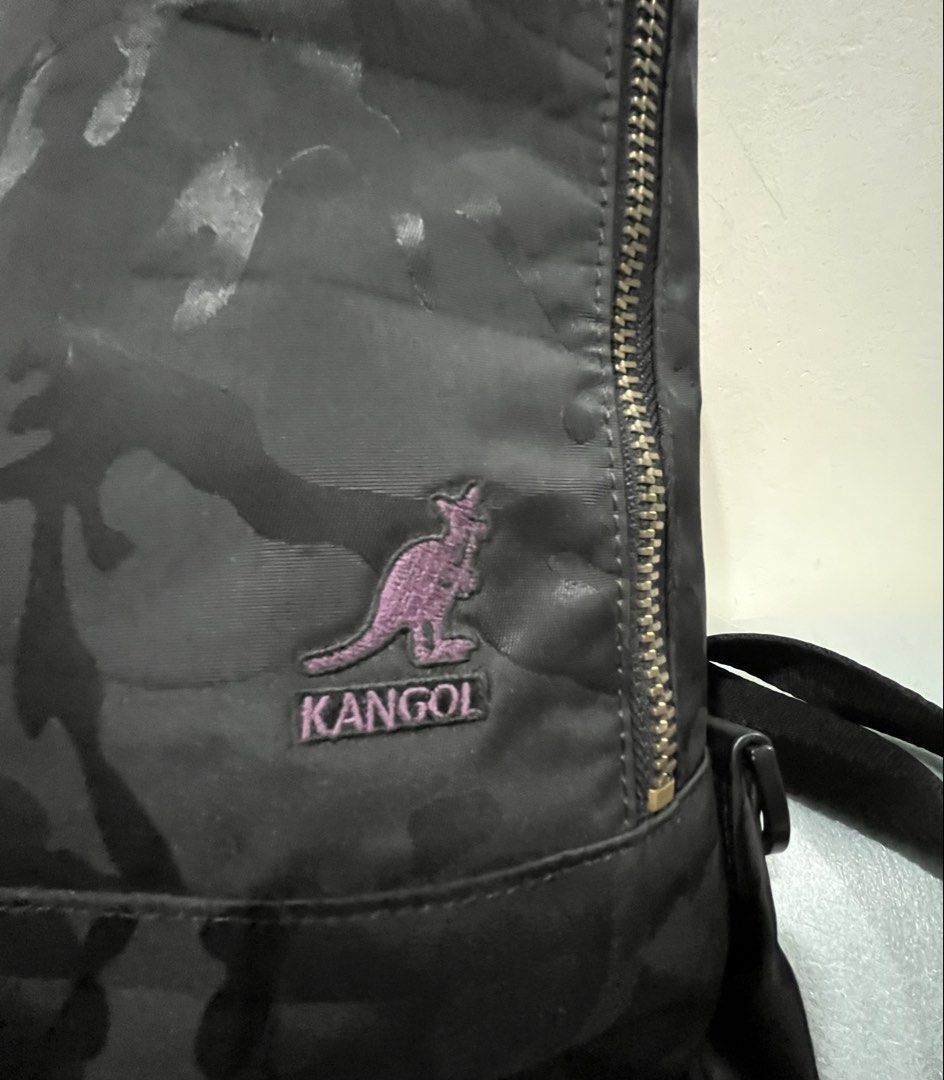 Kangol Camo Sling Bag Black (Category: Sling Bags) located in Talisay. Submitted by cherylu (Listing ID 1466975742, Image 2). Description: - Brand: Kangol - Design: Black camouflage with iconic purple embroidered kangaroo logo - Closure: Main zipper with branded leather pull tab - Interior: Bright purple lining with extra pockets and brand patch - Strap: Adjustable for comfortable daily wear - Size: Compact, perfect for carrying daily essentials.