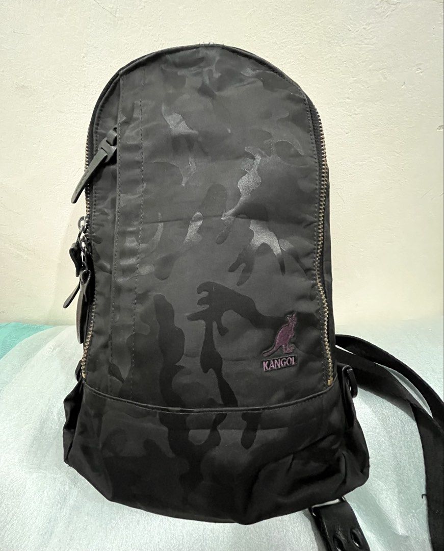 Kangol Camo Sling Bag Black (Category: Sling Bags) located in Talisay. Submitted by cherylu (Listing ID 1466975742, Image 1). Description: - Brand: Kangol - Design: Black camouflage with iconic purple embroidered kangaroo logo - Closure: Main zipper with branded leather pull tab - Interior: Bright purple lining with extra pockets and brand patch - Strap: Adjustable for comfortable daily wear - Size: Compact, perfect for carrying daily essentials.