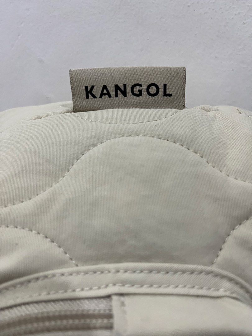 Kangol Quilted Beige Bucket Bag with Pompom (Category: Shoulder Bags) located in Talisay. Submitted by cherylu (Listing ID 1466976209, Image 2). Description: - Brand: Kangol - Color: Beige - Style: Quilted bucket bag with drawstring closure and top grab handle - Hardware: Silver-tone with engraved hooks and circular logo zipper pull - Pockets: Front zippered pocket - Extras: Includes detachable furry pompom charm and Kangol kangaroo leather keych