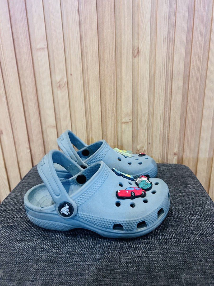Kids blue Crocs with car charms (Category: Babies & Kids Fashion) located in Manila. Submitted by shandyeran24835 (Listing ID 1466994527, Image 1). Description: - Brand/Item: Kids' Crocs Clogs - Size: C9 - Color: Light Blue - Details: Decorated with fun car charms including a red car on the toe - Features: Easy slip-on style, secure heel straps, standard ventilation holes - Condition: Minor signs of wear on soles and upper surface, plenty of life
