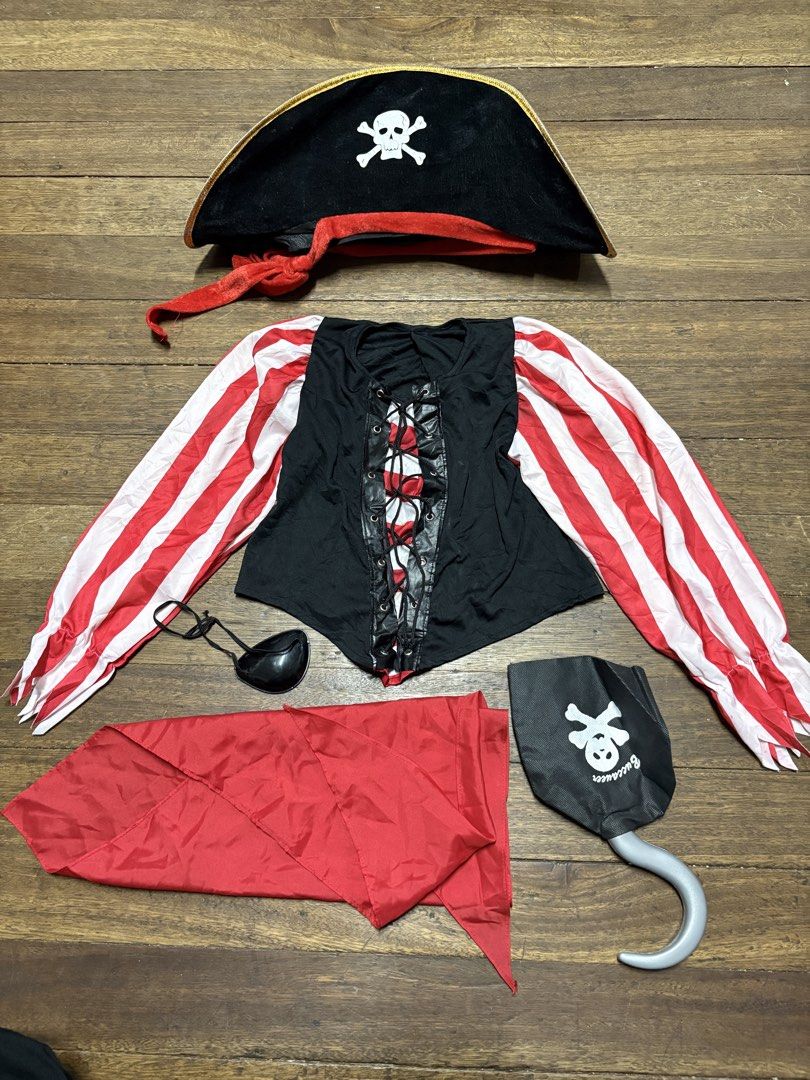Kids Pirate Costume Set with Hat Top Eye Patch Hook (Category: Babies & Kids Fashion) located in Manila. Submitted by keihlskloset (Listing ID 1467119613, Image 1). Description: - Complete pirate costume set for parties and Halloween - Includes: black laced top with striped sleeves, pirate hat, red sash, eye patch, and toy hook hand - Condition note: Some yellowish stains are visible on the striped fabric panels and sleeve area - Ready for your n