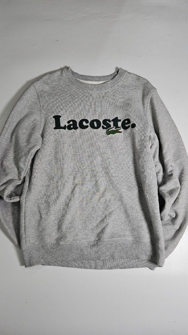 Lacoste big logo crewneck jacket (Category: Coats, Jackets and Outerwear) located in Alfonso. Submitted by jbcamet (Listing ID 1467073532, Image 1). Description: - Brand: Lacoste - Color: Grey with black vertical branding - Size: French 3 / US Small (Classic fit) - Material: 100% cotton for everyday comfort - Details: Iconic embroidered crocodile patch on the chest - Condition: Clean interior lining with tags intact - Origin: Made in China.