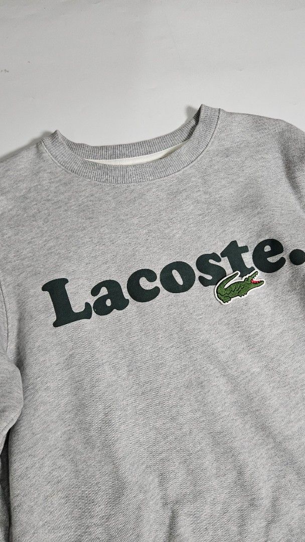 Lacoste big logo crewneck jacket (Category: Coats, Jackets and Outerwear) located in Alfonso. Submitted by jbcamet (Listing ID 1467073532, Image 2). Description: - Brand: Lacoste - Color: Grey with black vertical branding - Size: French 3 / US Small (Classic fit) - Material: 100% cotton for everyday comfort - Details: Iconic embroidered crocodile patch on the chest - Condition: Clean interior lining with tags intact - Origin: Made in China.