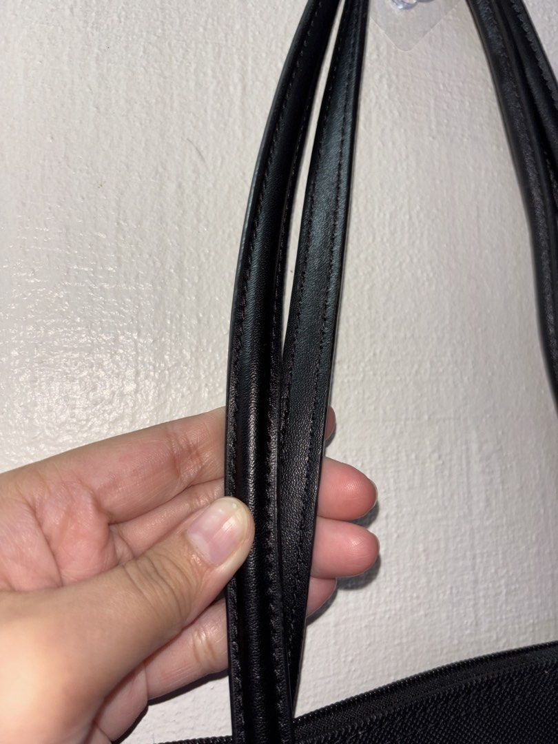 Lacoste Black Canvas Tote Bag with Leather Straps (Category: Tote Bags) located in Tarlac. Submitted by chosowakatoshi (Listing ID 1467096229, Image 3). Description: - Brand: Lacoste - Material: Textured black canvas with sturdy black leather shoulder straps - Closure: Top zipper with branded leather pull tag - Branding: Iconic green crocodile logo patch on the upper front - Interior: Roomy and spacious, ideal for daily essentials - Style: Minima