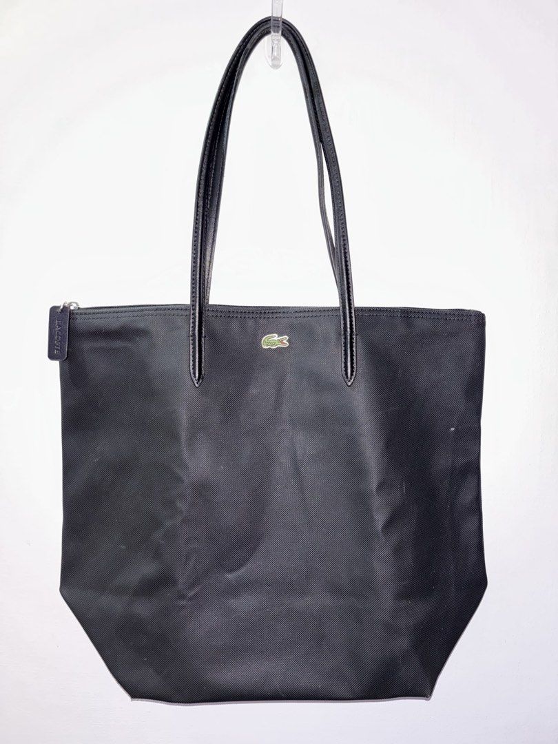 Lacoste Black Canvas Tote Bag with Leather Straps (Category: Tote Bags) located in Tarlac. Submitted by chosowakatoshi (Listing ID 1467096229, Image 1). Description: - Brand: Lacoste - Material: Textured black canvas with sturdy black leather shoulder straps - Closure: Top zipper with branded leather pull tag - Branding: Iconic green crocodile logo patch on the upper front - Interior: Roomy and spacious, ideal for daily essentials - Style: Minima