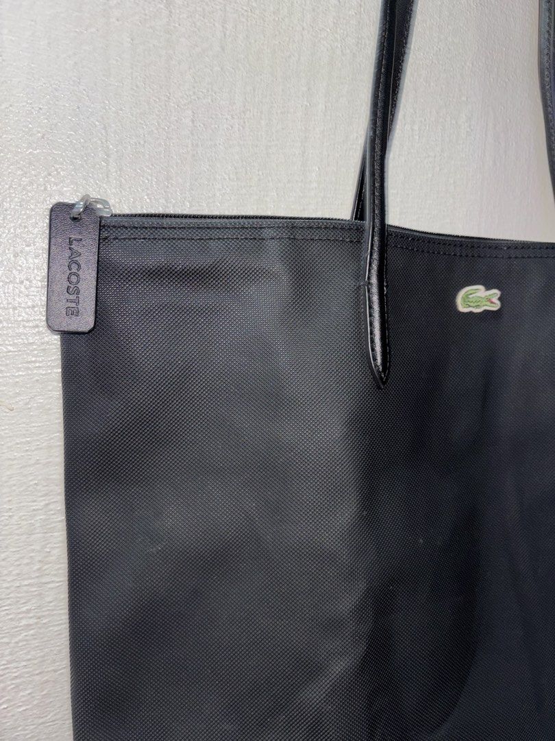 Lacoste Black Canvas Tote Bag with Leather Straps (Category: Tote Bags) located in Tarlac. Submitted by chosowakatoshi (Listing ID 1467096229, Image 2). Description: - Brand: Lacoste - Material: Textured black canvas with sturdy black leather shoulder straps - Closure: Top zipper with branded leather pull tag - Branding: Iconic green crocodile logo patch on the upper front - Interior: Roomy and spacious, ideal for daily essentials - Style: Minima