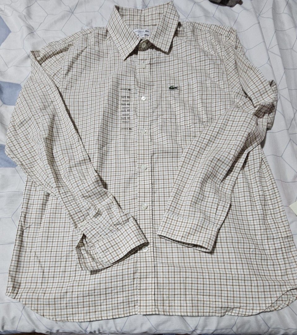 Lacoste Checkered Long Sleeve Button-Down Shirt Size 40 Medium (Category: Luxury Apparel) located in Davao. Submitted by dahl957172787 (Listing ID 1466972880, Image 1). Description: - Brand: Lacoste - Style: Long sleeve button-down shirt - Pattern: Cream and brown checkered - Size: 40 (Equivalent to Medium, standard fit) - Details: Classic collar, front button closure, single chest pocket with iconic green crocodile embroidery - Material: Crisp, 