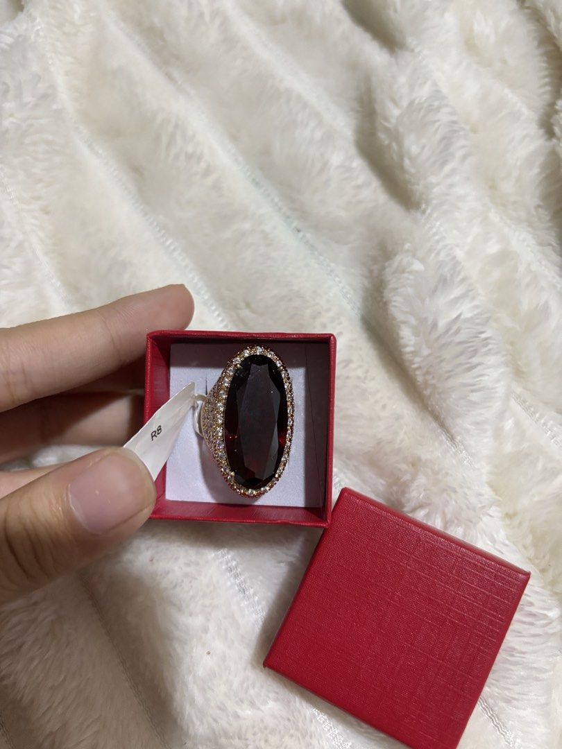 Large Oval Red Stone Ring with Pave Setting (Category: Rings) located in Quezon City. Submitted by hadescloset (Listing ID 1467062760, Image 2). Description: - Bold cocktail ring featuring a striking large red oval center stone - Rose gold band fully covered in sparkling pave stones - Eye-catching statement piece that catches the light beautifully - Comes in a stylish small red square box with a white insert.