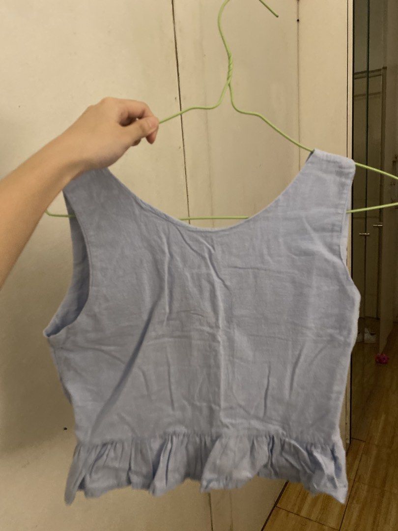 Light Blue V-Neck Ruffle Hem Crop Top (Category: Sleeveless) located in Manila. Submitted by tonialalelilolu (Listing ID 1467061469, Image 2). Description: - Color: Light blue - Style: Sleeveless crop top with V-neckline and peplum ruffle hem - Material: Slight textured weave - Fit: Hits right above the waist, easy to pair with high-waisted jeans or skirts - Condition: Clean with no obvious stains or flaws.
