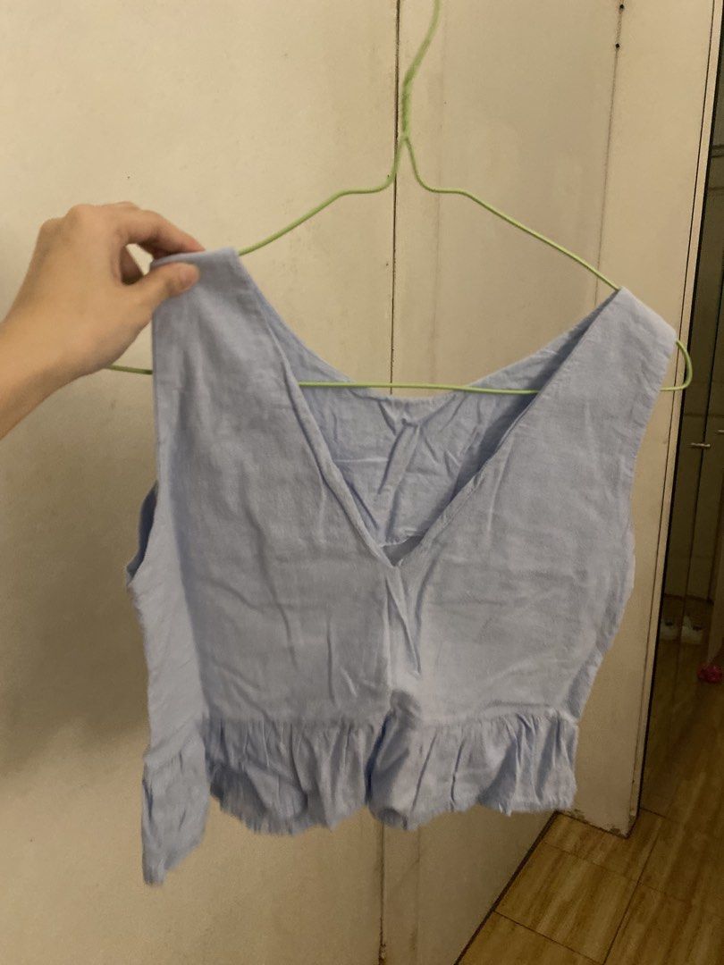 Light Blue V-Neck Ruffle Hem Crop Top (Category: Sleeveless) located in Manila. Submitted by tonialalelilolu (Listing ID 1467061469, Image 1). Description: - Color: Light blue - Style: Sleeveless crop top with V-neckline and peplum ruffle hem - Material: Slight textured weave - Fit: Hits right above the waist, easy to pair with high-waisted jeans or skirts - Condition: Clean with no obvious stains or flaws.