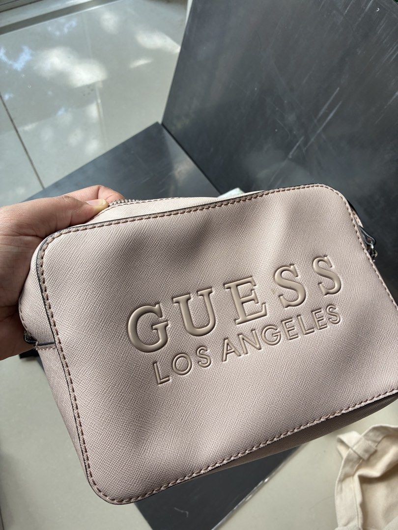 Light pink Guess (Category: Shoulder Bags) located in Manila. Submitted by jhie24 (Listing ID 1464191839, Image 3). Description: - Light pink Guess - 'Guess Los Angeles' logo embossed on the front - Interior features Guess logo lining and multiple pockets - Includes four bonus pouches: black, holographic, patterned zippered, and small pink/brown - with minor marks on the exterior.