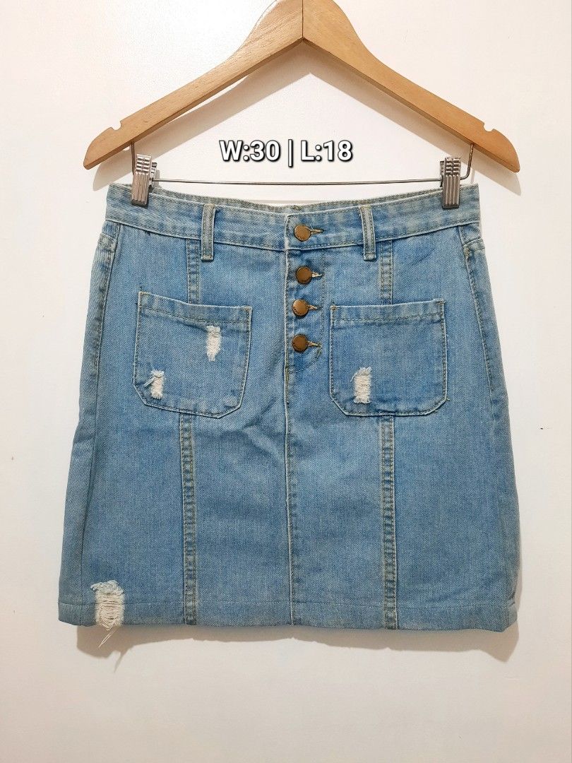 Light wash distressed denim skirt with front buttons (Category: Skirts) located in Cavite. Submitted by YANAminicloset (Listing ID 1467167148, Image 1). Description: - Style: Light wash denim skirt with vertical panel stitching - Details: Button-up front with 4 brass-toned buttons, 2 front patch pockets, and edgy distressing on the pockets and bottom left hem - Measurements: Waist 30" | Length 18" - Material: Sturdy, high-quality denim - Conditio