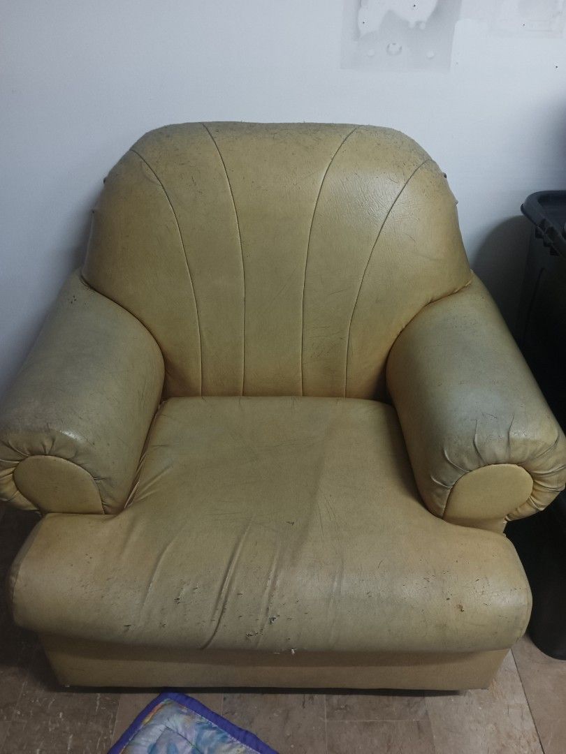 Living room sofa set and armchairs (Category: Sofas) located in Quezon City. Submitted by jimi_1999 (Listing ID 1467030945, Image 3). Description: ‼️PRICE NEGOTIABLE‼️ - Needs upholstery. - Foam insides intact. RFS: Buying a new set of couches. - Complete living room set: 1 large sofa and 2 armchairs - Solid frame construction ready for a makeover - Original yellow-beige leather shows visible wear, stains, and scratches - Includes one blue/beige 