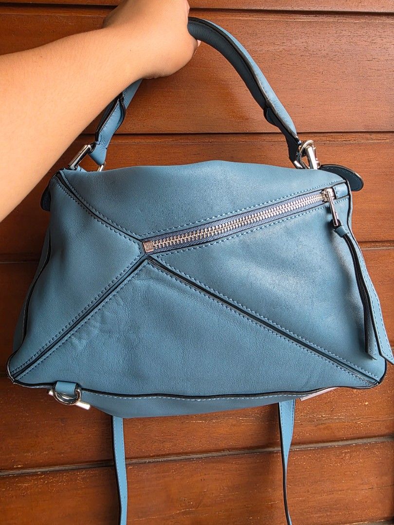Loewe Puzzle Bag Blue Leather (Category: Sling Bags) located in Lemery. Submitted by venus23 (Listing ID 1467065677, Image 2). Description: - Brand: Loewe Puzzle Bag - Color: Classic Blue - Material: Premium leather with distinct geometric paneling - Hardware: Silver-tone with protective base feet - Straps: Rolled leather top handle and adjustable shoulder strap - Details: Debossed anagram logo and contrast edge painting - Interior: Spacious main