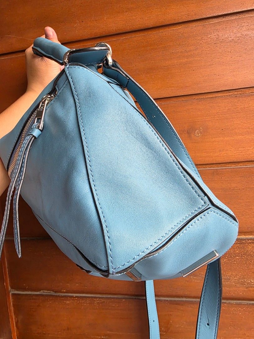 Loewe Puzzle Bag Blue Leather (Category: Sling Bags) located in Lemery. Submitted by venus23 (Listing ID 1467065677, Image 3). Description: - Brand: Loewe Puzzle Bag - Color: Classic Blue - Material: Premium leather with distinct geometric paneling - Hardware: Silver-tone with protective base feet - Straps: Rolled leather top handle and adjustable shoulder strap - Details: Debossed anagram logo and contrast edge painting - Interior: Spacious main