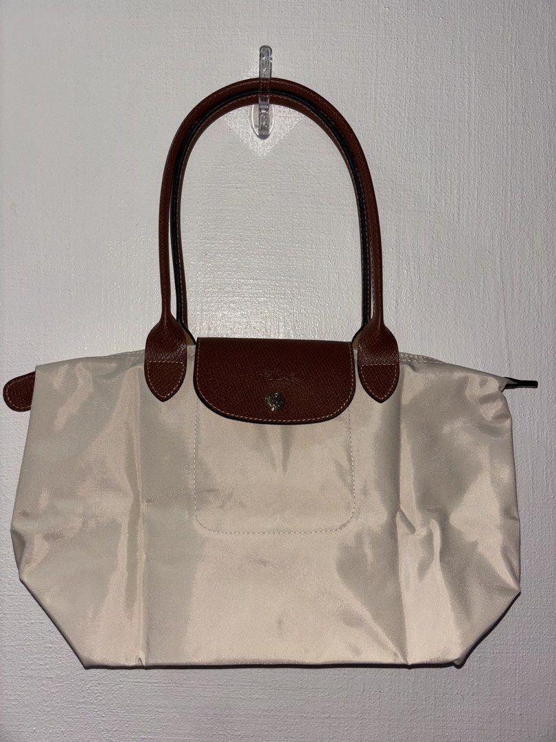 Longchamp Le Pliage Beige Tote Bag (Category: Luxury Bags & Wallets) located in Tarlac. Submitted by chosowakatoshi (Listing ID 1467095810, Image 1). Description: -Longchamp tote bag - Elegant beige nylon body with structured brown leather trim - Secure front flap with snap button closure - Classic gold-tone hardware details - Clean leather handles with nice contrast stitching - Spacious and perfect for daily use or travel - RUSH SALE / PM for in