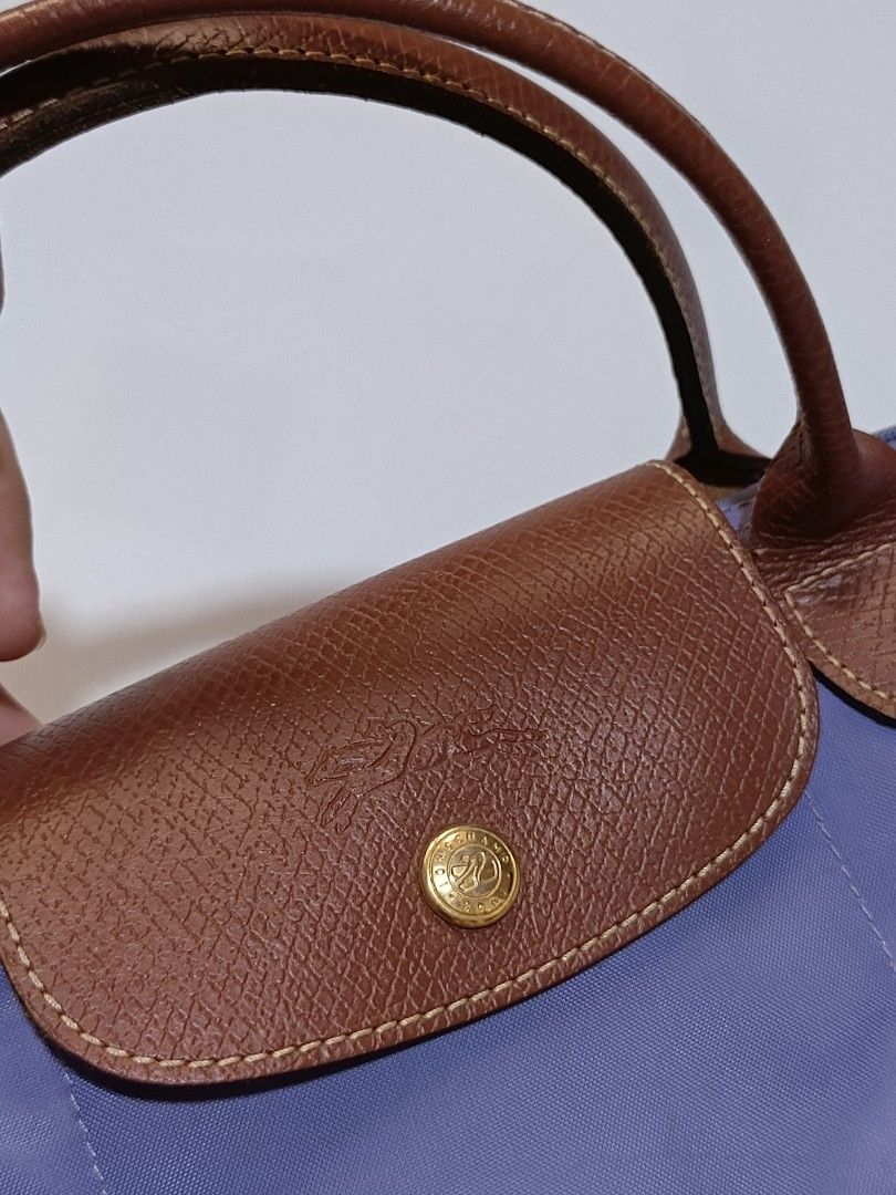 LongChamp Le Pliage Original (Category: Luxury Bags & Wallets) located in Tacloban City. Submitted by agnescthrifted98 (Listing ID 1467023986, Image 2). Description: Longchamp Le Pliage Original short-handle tote bag in a periwinkle / lavender blue shade with brown Russian leather trim and gold-tone hardware no bubbles but slightly need malinis sa loob few rubs sa corner no issue sa mga leather niya. dimes 8x12 inches 6x8 inches can fit umbrella.