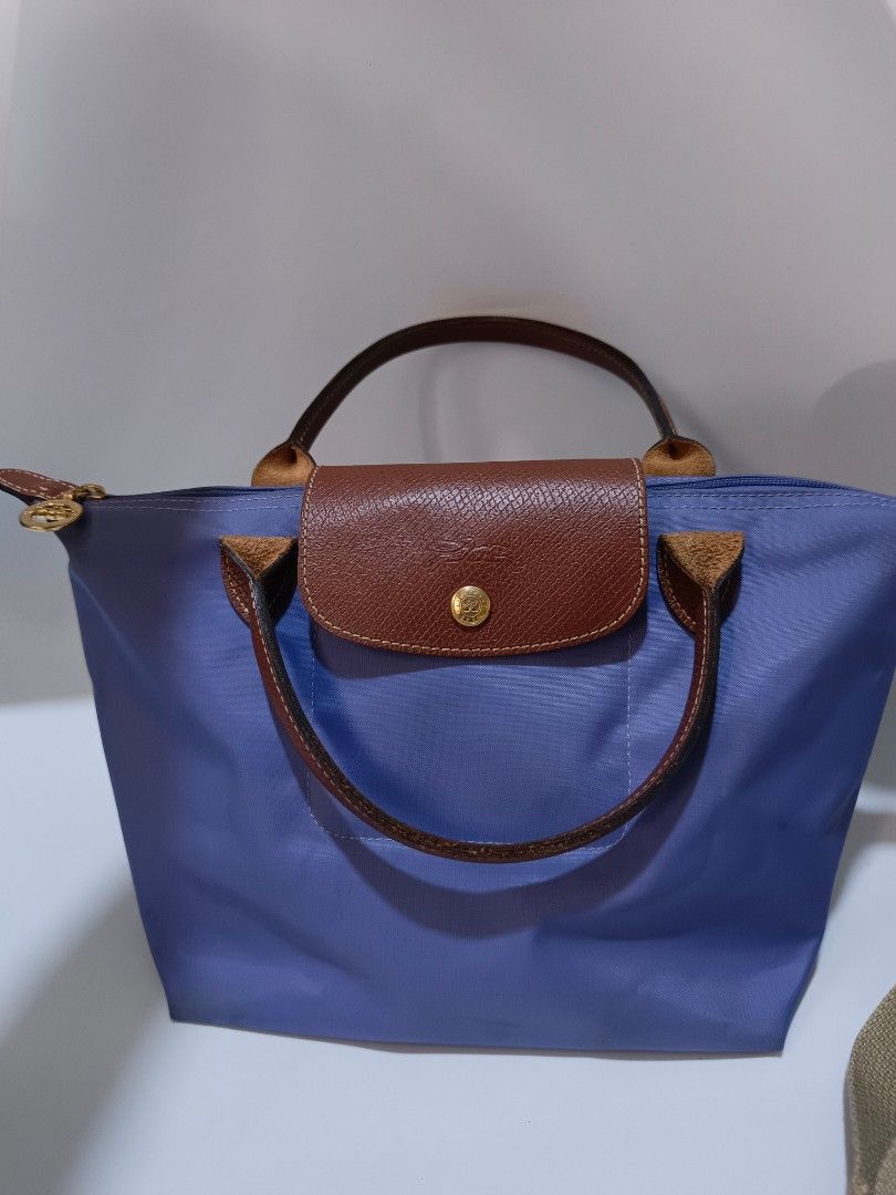 LongChamp Le Pliage Original (Category: Luxury Bags & Wallets) located in Tacloban City. Submitted by agnescthrifted98 (Listing ID 1467023986, Image 1). Description: Longchamp Le Pliage Original short-handle tote bag in a periwinkle / lavender blue shade with brown Russian leather trim and gold-tone hardware no bubbles but slightly need malinis sa loob few rubs sa corner no issue sa mga leather niya. dimes 8x12 inches 6x8 inches can fit umbrella.