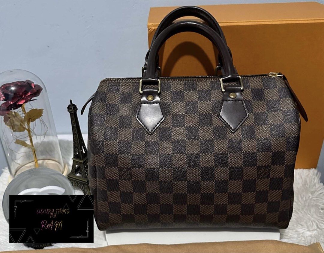 Louis Vuitton Damier Ebene Speedy Handbag (Category: Luxury Bags & Wallets) located in Manila. Submitted by rhea.1215 (Listing ID 1467167094, Image 1). Description: - Brand: Louis Vuitton - Model: Speedy Handbag - Material: Damier Ebene canvas with dark brown leather trim - Hardware: Gold-tone with engraved zipper pull - Features: Double rolled leather top handles, secure zip closure, and iconic LV Paris stamped front tab - Condition: Excellent, 