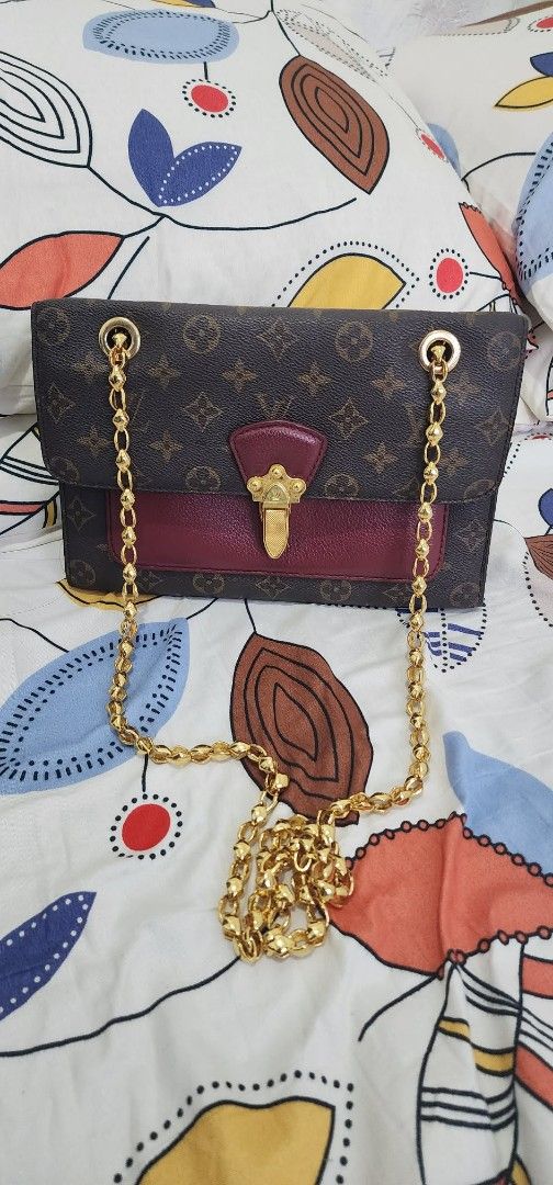 Louis Vuitton Monogram Canvas Flap Bag with Gold Chain (Category: Luxury Bags & Wallets) located in Gerona. Submitted by mel_45 (Listing ID 1466978857, Image 1). Description: Authentic Louis Vuitton monogram flap bag in brown canvas with a striking burgundy leather front flap and gold-tone hardware. Features a chunky gold chain strap and a structured, clean silhouette that easily fits your daily essentials. Perfect statement piece for any outfit.