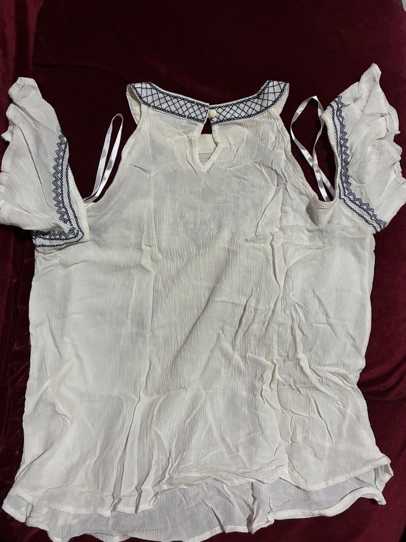 Love Fire White Cold Shoulder Embroidered Blouse Size M (Category: Blouses) located in Quezon City. Submitted by judsnasps (Listing ID 1467122290, Image 3). Description: - Brand: Love Fire - Size: Medium - Color: White with dark blue embroidery details - Design: Cold shoulder with ruffle sleeves and back neck button closure - Material: Lightweight fabric, ideal for warm weather - Condition: Clean and ready to wear.