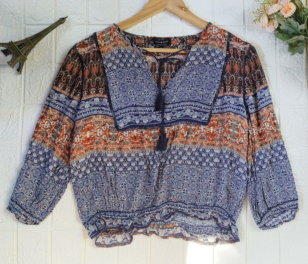 Lucky Brand Boho V-Neck Printed Blouse Size M (Category: Blouses) located in Tagbilaran City. Submitted by grazie95 (Listing ID 1467034880, Image 1). Description: - Brand: Lucky Brand - Size: M - Style: Boho relaxed fit top - Colors & Pattern: Blue and rust orange with mixed medallion and tribal prints - Details: V-neckline with tie strings and tassels, 3/4 sleeves, and an elasticated hem - Condition: Great casual piece for everyday wear .