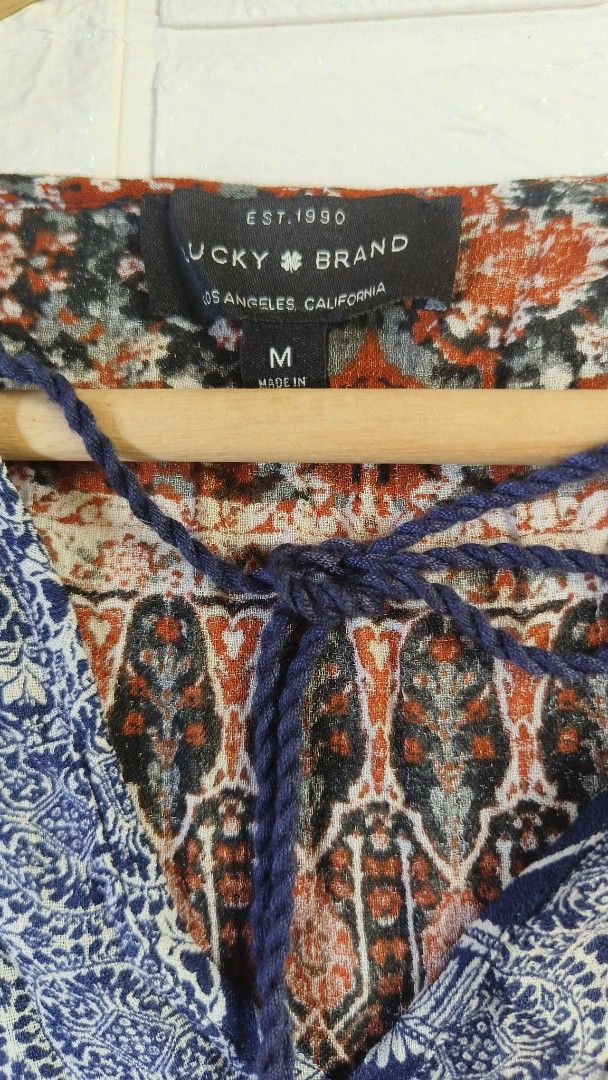 Lucky Brand Boho V-Neck Printed Blouse Size M (Category: Blouses) located in Tagbilaran City. Submitted by grazie95 (Listing ID 1467034880, Image 2). Description: - Brand: Lucky Brand - Size: M - Style: Boho relaxed fit top - Colors & Pattern: Blue and rust orange with mixed medallion and tribal prints - Details: V-neckline with tie strings and tassels, 3/4 sleeves, and an elasticated hem - Condition: Great casual piece for everyday wear .