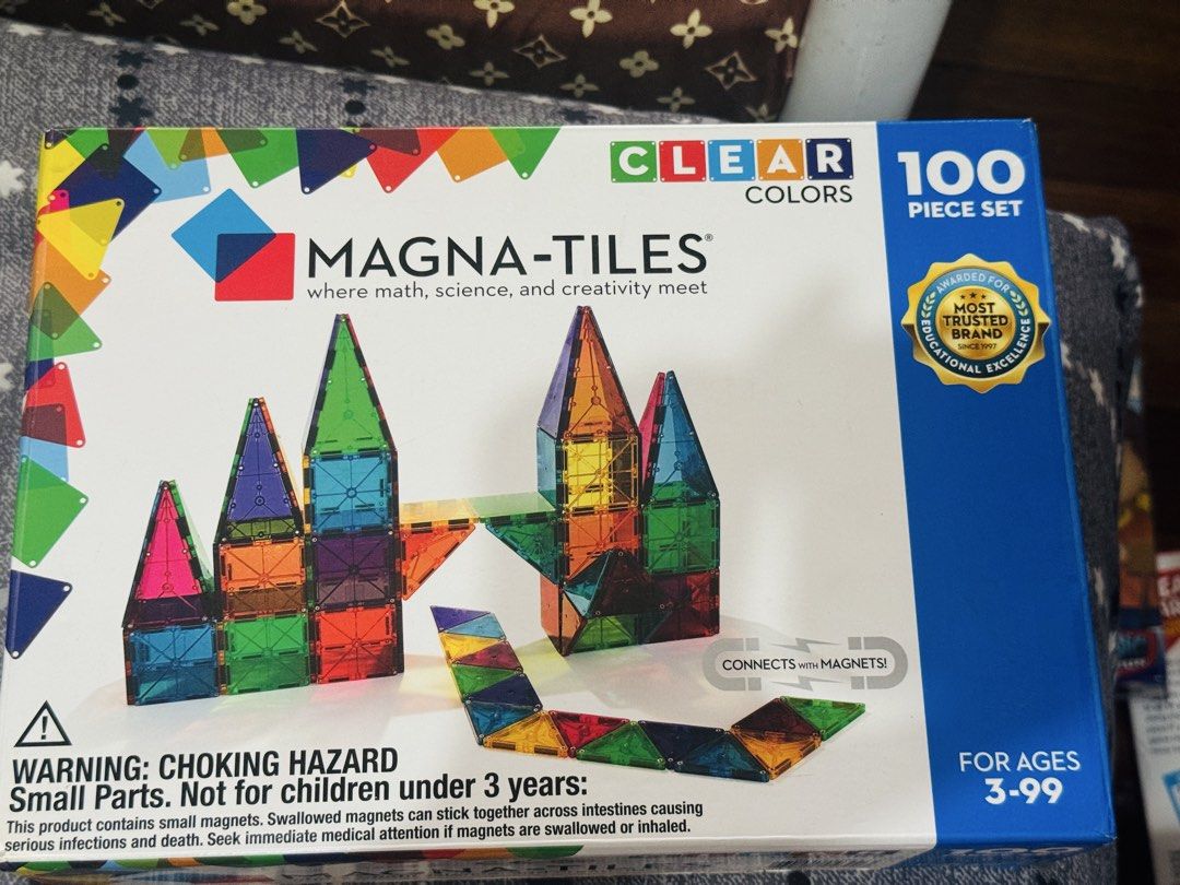 Magna-Tiles Clear Colors 100 Piece Set (Category: Board Games & Puzzles) located in San Pedro. Submitted by shopwithgianna (Listing ID 1466990513, Image 1). Description: - Authentic Magna-Tiles Clear Colors 100-Piece Set - Includes large squares, small squares, equilateral triangles, right triangles, and isosceles triangles - Encourages STEM learning, creative problem solving, and imaginative play - Comes with original box packaging.