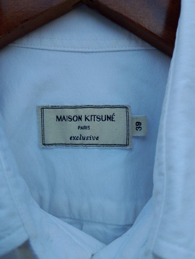 Maison Kitsuné Double Fox Head Patch Button-Down Shirt (Category: Tshirts & Polo Shirts ) located in Baliuag. Submitted by retrovault83 (Listing ID 1467138681, Image 3). Description: ✨ Condition: 9/10 – Great Preloved Condition (Minor flaws noted below, guaranteed authentic) 📏 Measurements (Flat Lay, Tagged Size 39 / Medium): • Pit to Pit: 20.5 • Length: 26.5 ✅ Details: • Crisp white cotton oxford body featuring the signature embroidered Grey & 