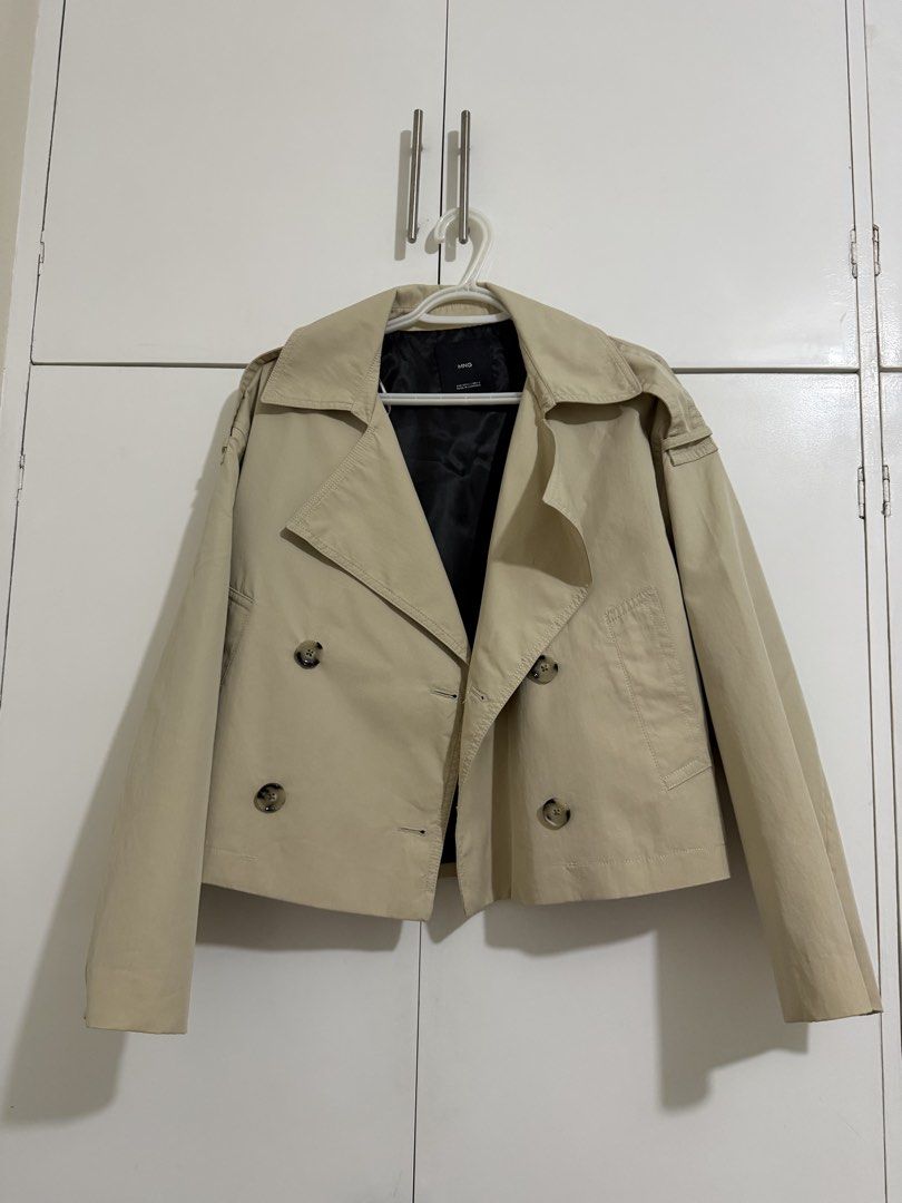 Mango Beige Cropped Trench Jacket (Category: Coats, Jackets and Outerwear) located in Manila. Submitted by hhhhcloset (Listing ID 1467069074, Image 1). Description: - Brand: MNG - Size: L (EUR/USA L, MEX G) - Color: Classic beige with black inner lining - Material/Origin: Made in Cambodia - Design: Double-breasted button front, wide lapels, structured shoulders - Style: Cropped trench jacket, perfect for layering during transitional weather.