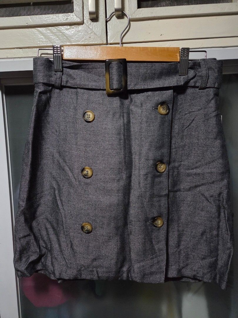 MANGO Casual grey herringbone patterned skirt with belt (Category: Skirts) located in Pasig City. Submitted by ldcayas (Listing ID 1467082861, Image 1). Description: - Brand: MNG Casual (Made in Turkey) - Size: EUR S, USA XS, MEX CH - Design: Grey herringbone pattern, high-waisted - Details: Double-breasted front with contrasting brown buttons, includes matching belt with dark buckle - Style: Great piece for smart casual outfits Mode of Payment G