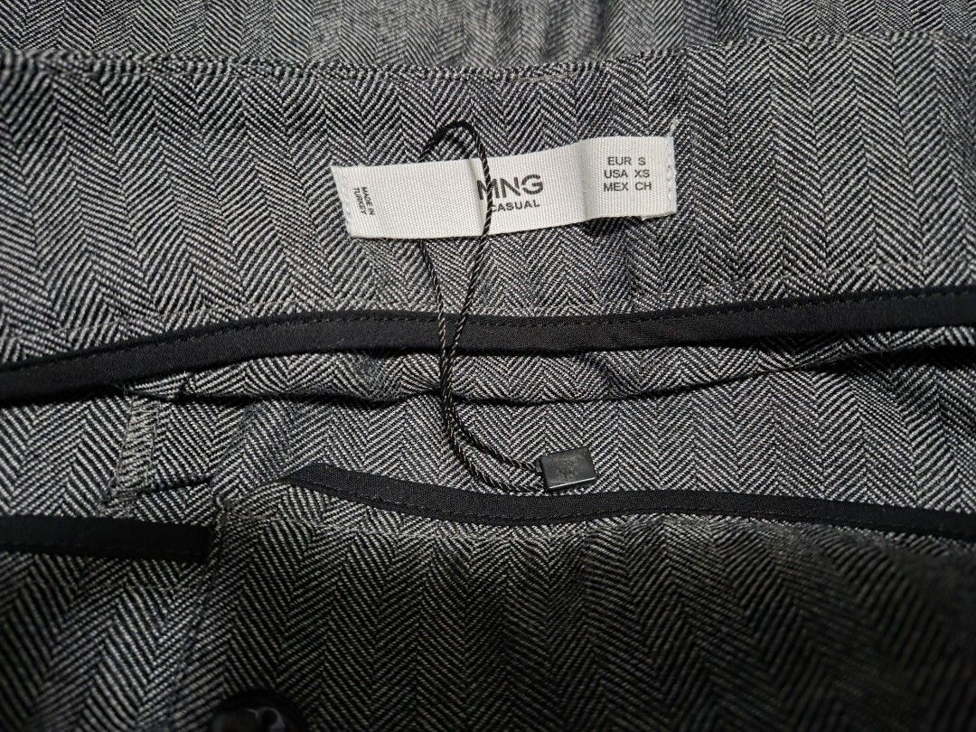MANGO Casual grey herringbone patterned skirt with belt (Category: Skirts) located in Pasig City. Submitted by ldcayas (Listing ID 1467082861, Image 2). Description: - Brand: MNG Casual (Made in Turkey) - Size: EUR S, USA XS, MEX CH - Design: Grey herringbone pattern, high-waisted - Details: Double-breasted front with contrasting brown buttons, includes matching belt with dark buckle - Style: Great piece for smart casual outfits Mode of Payment G