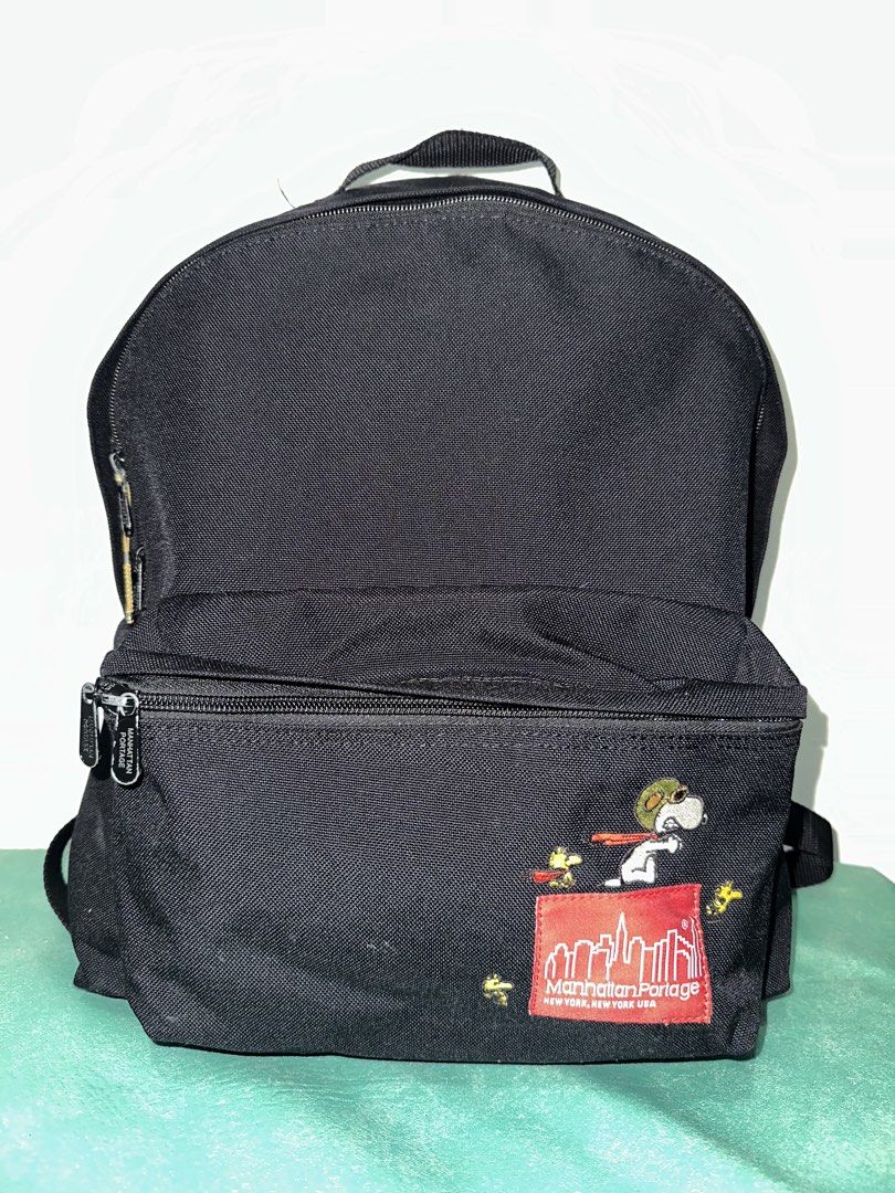 Manhattan Portage x Peanuts Snoopy Backpack (Category: Backpacks) located in Quezon City. Submitted by swift.thriftz (Listing ID 1467127659, Image 1). Description: - Limited edition Manhattan Portage x Peanuts collaboration backpack - Durable black canvas material with classic red logo patch - Features embroidered Flying Ace Snoopy and Woodstock on the front pocket - Unique camouflage inner lining with 65th anniversary Peanuts tag - Secure zipper