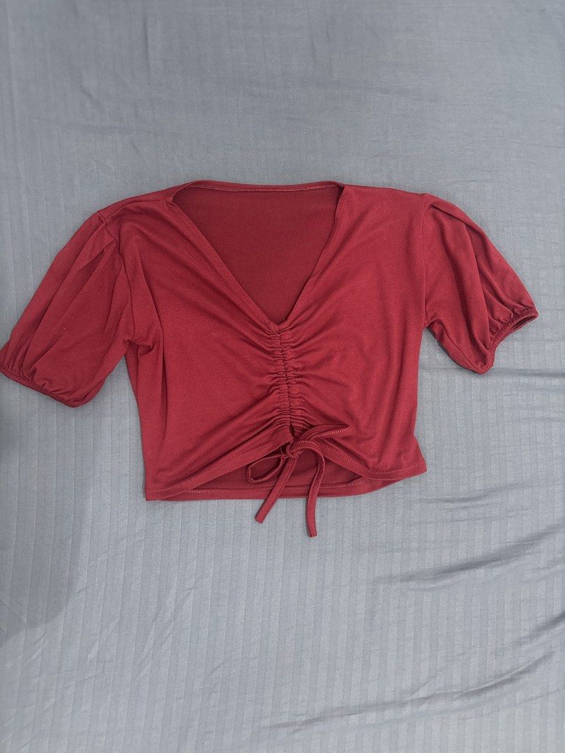 Maroon V-Neck Ruched Drawstring Short Sleeve Crop Top (Category: Shirts) located in Makati City. Submitted by blueberrylime (Listing ID 1466974896, Image 1). Description: - Color: Maroon - Style: Short sleeve crop top with deep V-neckline and puff sleeves - Details: Center front ruching and adjustable drawstring tie at the hem - Fit: Soft, stretchy fabric with elastic cuffs - Condition: Clean, no flaws spotted - Pairing: Great with high-waisted j