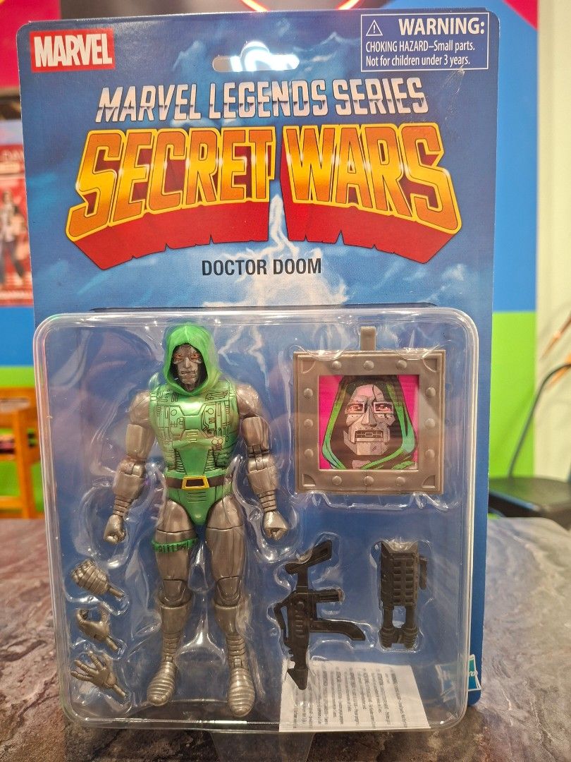 Marvel Legends Secret Wars Doctor Doom Action Figure (Category: Figurines & Statues) located in Mandaluyong City. Submitted by elitecollections (Listing ID 1467070813, Image 1). Description: - Item: Marvel Legends Secret Wars Doctor Doom figure - Condition: Brand new, Mint in Box (MIB), unopened packaging - Design: Classic green and silver suit - Includes: Alternate hands, weapons, and a framed picture accessory - Perfect for: Marvel fans and ret