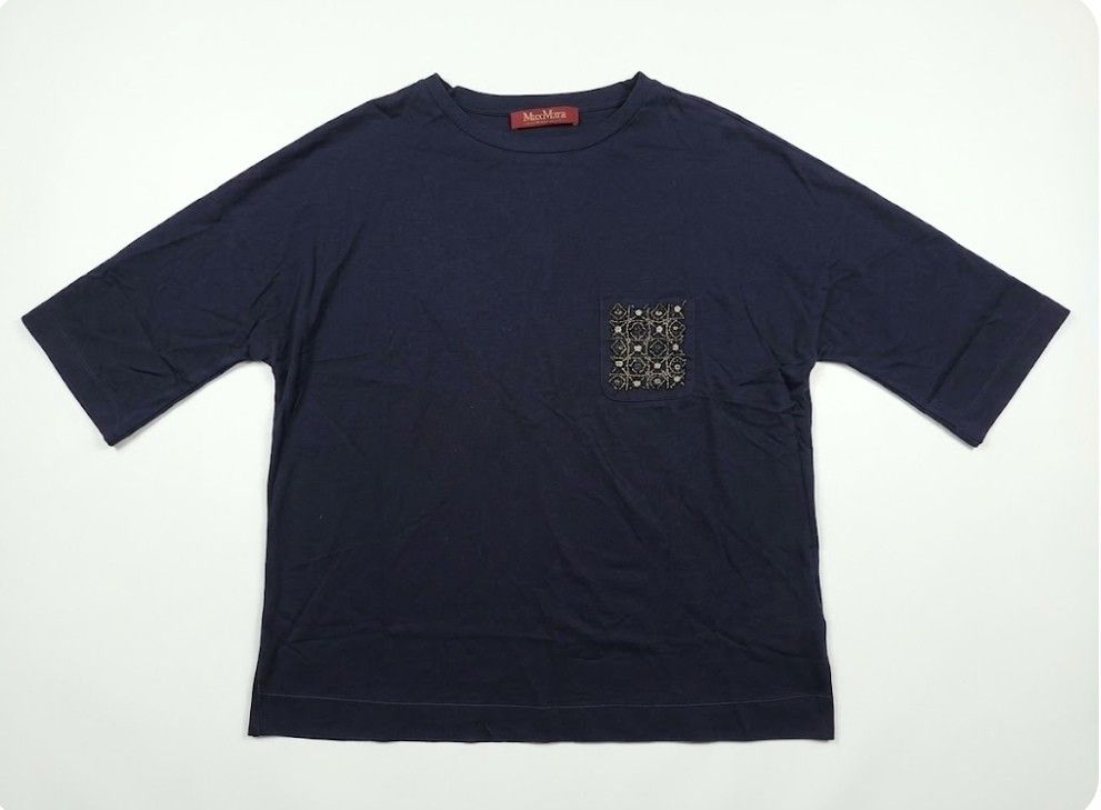 Max Mara Studio Navy Beaded Pocket Tee (Category: Shirts) located in Donsol. Submitted by saksthriftavenuebyluckymaria8 (Listing ID 1467168110, Image 2). Description: - Brand: Max Mara Studio - Color: Navy Blue - Fit: Relaxed fit with dropped shoulders - Detail: Left chest pocket with detailed beading, metallic tubes, crystals, and faux pearls - Material: Clean, high-quality cotton fabric - Authenticity: Red brand label on the inner collar - Cond