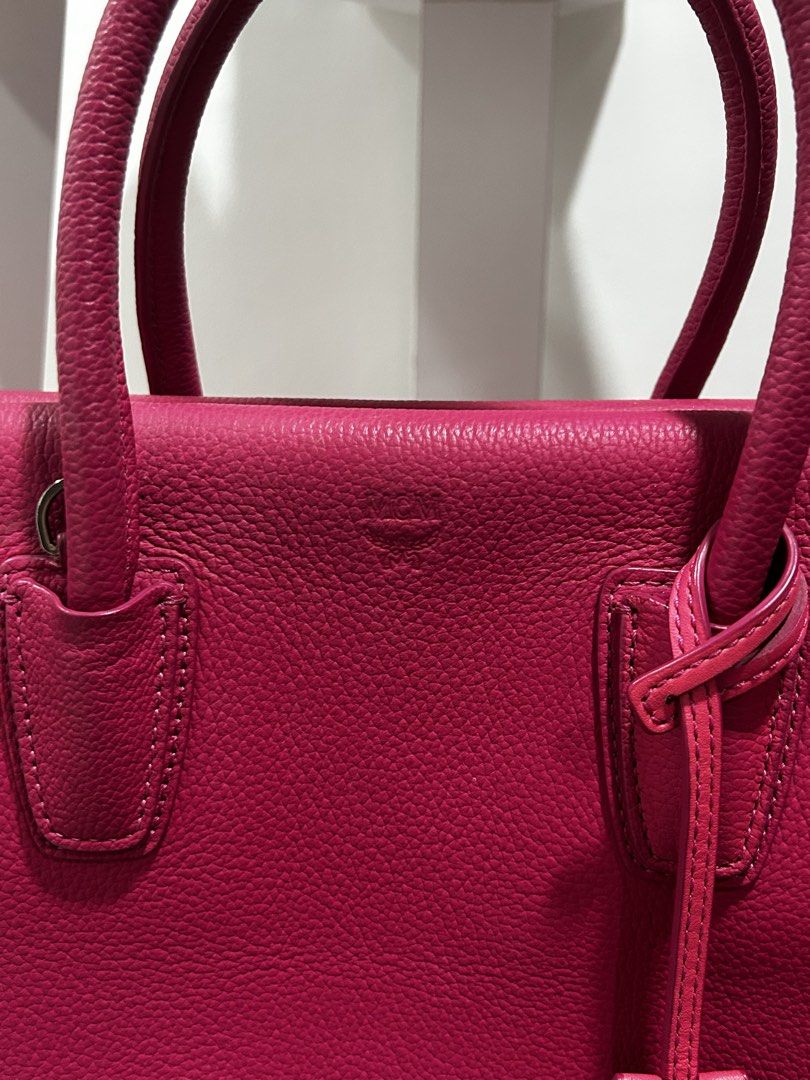 MCM Pink Milla Leather Tote Bag with Orig Dustbag (Category: Luxury Bags & Wallets) located in Rizal. Submitted by bebangel (Listing ID 1467100618, Image 2). Description: - Brand: MCM - Material: Pebbled leather in a vibrant bright pink - Features: Dual top handles, hanging charm with embossed logo hardware, structured shape, clean stitching - Condition: Overall clean exterior and handles, with a minor scuff mark on one bottom corner and a small 