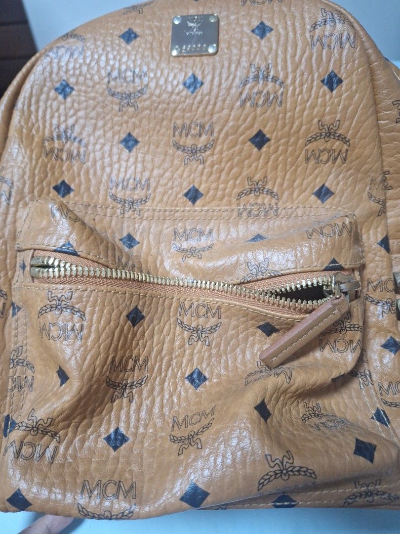 MCM Stark Studded Visetos Coated Canvas Backpack Cognac (Category: Luxury Bags & Wallets) located in Manila. Submitted by loydamariano (Listing ID 1466970934, Image 2). Description: - Brand/Model: Classic MCM Stark Backpack - Material/Color: Iconic Visetos monogram leather in Cognac - Details: Vertical pyramid studs, front zip pocket, spacious main compartment, and gold-tone hardware - Design: Flat sturdy base keeps the bag upright when placed do