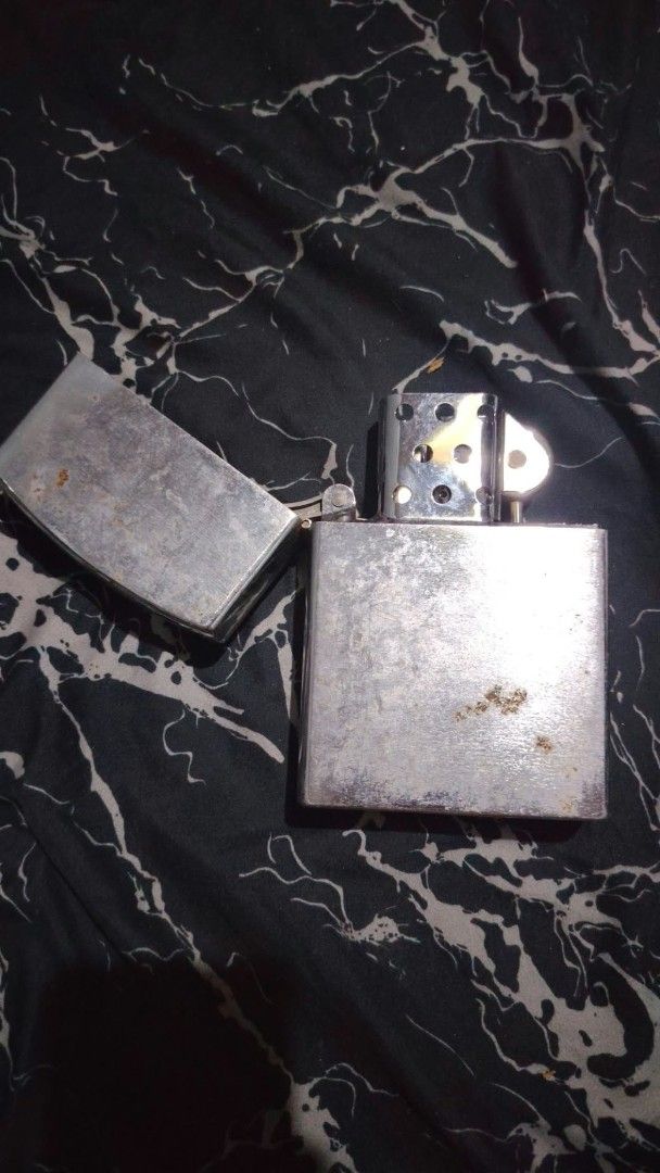 Metal Windproof Lighter (Category: Fragrance & Deodorants) located in Caloocan City. Submitted by chuaniki (Listing ID 1467154350, Image 1). Description: - Silver metal windproof lighter with a classic flip-top design - Features a weathered finish with visible surface scuffs and minor rust spots - Solid hinge mechanism and standard insert unit fully intact - Needs fluid and flint replacement - Great vintage everyday carry (EDC) piece.