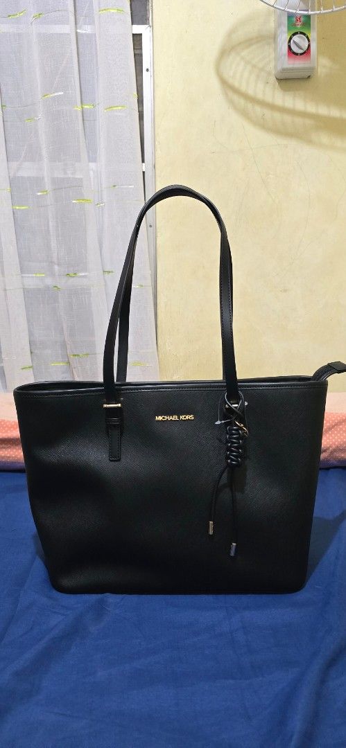 Michael Kors Black Tote Bag (Category: Tote Bags) located in Rizal. Submitted by pispis190611 (Listing ID 1467100579, Image 3). Description: - Brand: Michael Kors - Material: Premium black saffiano leather - Hardware: Elegant gold-toned accents with front logo stamp - Straps: Double shoulder straps with adjustable buckles - Details: Chic braided leather hanging accent - Closure: Secure zip-top closure - Condition: Excellent / Well-maintained - Pe