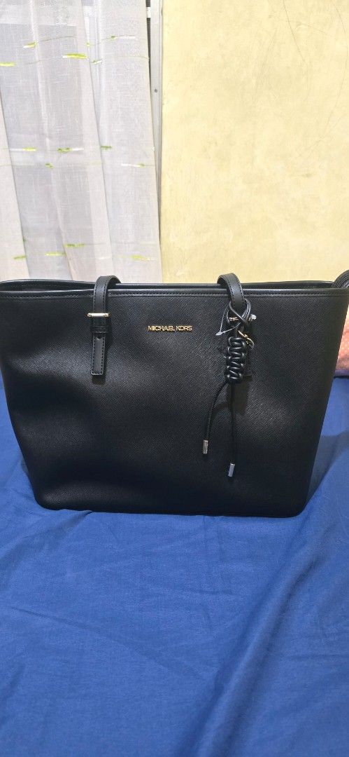 Michael Kors Black Tote Bag (Category: Tote Bags) located in Rizal. Submitted by pispis190611 (Listing ID 1467100579, Image 2). Description: - Brand: Michael Kors - Material: Premium black saffiano leather - Hardware: Elegant gold-toned accents with front logo stamp - Straps: Double shoulder straps with adjustable buckles - Details: Chic braided leather hanging accent - Closure: Secure zip-top closure - Condition: Excellent / Well-maintained - Pe